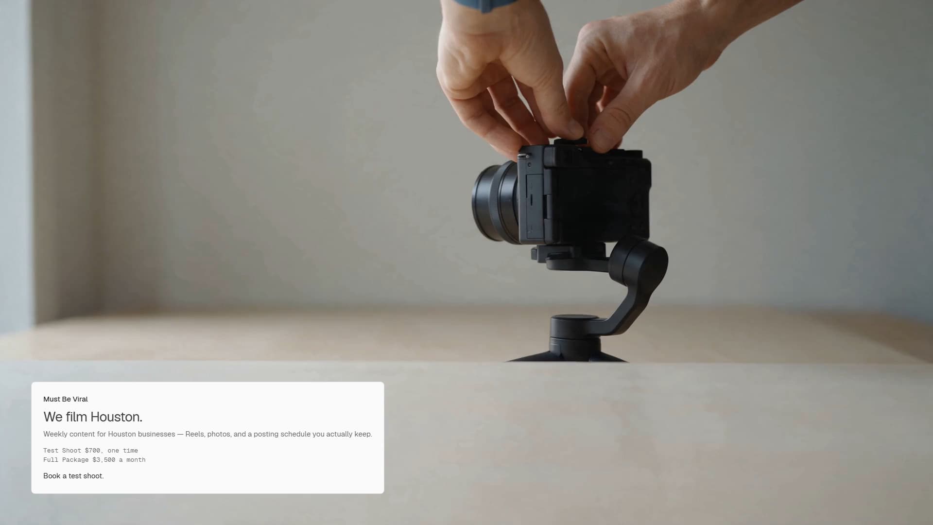 Two hands adjust a camera on a gimbal in a generated room. The Must Be Viral offer is on the picture.